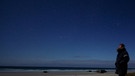 Sternbild Delphin neben Sommerdreieck aus den Sternbildern Schwan, Adler und Leier über einem Strand in Frankreich. | Bild: imago/Leemage