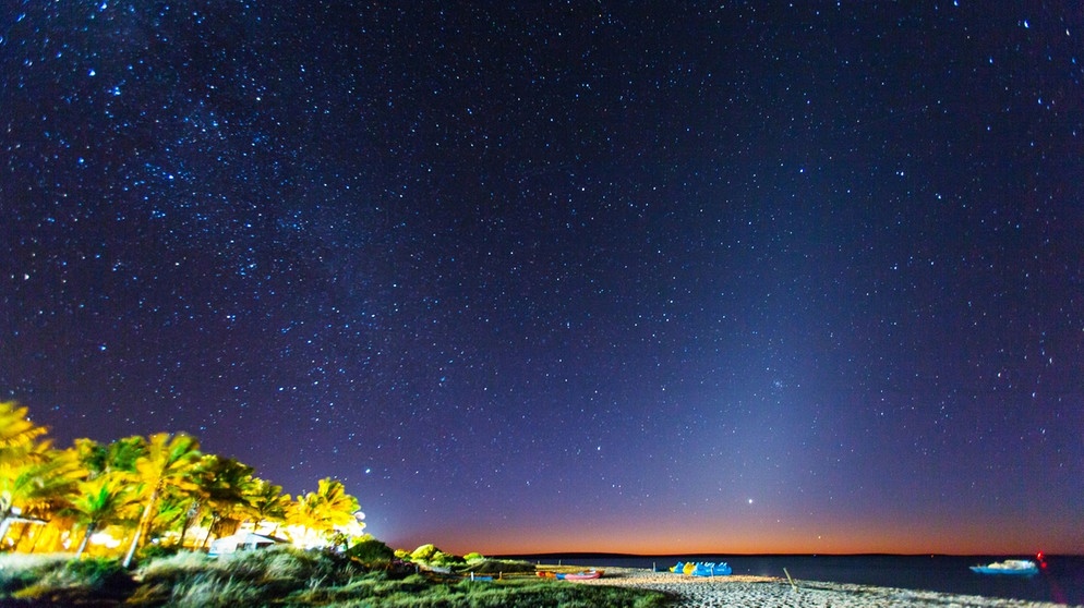 Das Tierkreislicht (auch: Zodiakallicht, rechts im Bild) neben der Milchstraße (links) am Sternenhimmel über einem australischen Strand. | Bild: picture-alliance/dpa