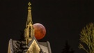 Der Blutmond bei totaler Mondfinsternis am 21. Januar 2019, halb versteckt hinter einer Kirche in Arnsberg. Fotografiert von Britta Lieder | Bild: Britta Lieder