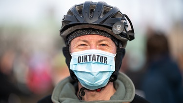 Mann mit medizinischer Maske und Aufschrieb "Diktatur" | Bild: picture alliance/dpa | Daniel Reinhardt