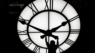 Ein Techniker in Medfiel (USA) bewegt die Uhrzeiger einer 500 kg schweren Uhr mit einem Durchmesser von mehr als 3,5 Metern, die für ein Resort in Vietnam gebaut wurde. | Bild: dpa-Bildfunk/Elise Amendola